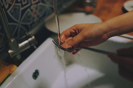 Freelance translator washing up a fork